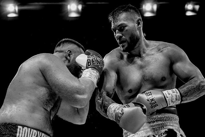 Boxer Tom Schwartz im Kampf während sich der Gegner deckt